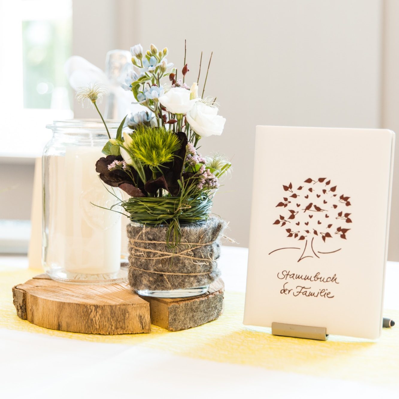 Hochzeitsdekoration mit Blumen und Kerze Tischdekoration mit Blumen, Kerze und Stammbuch bei einer Hochzeit.