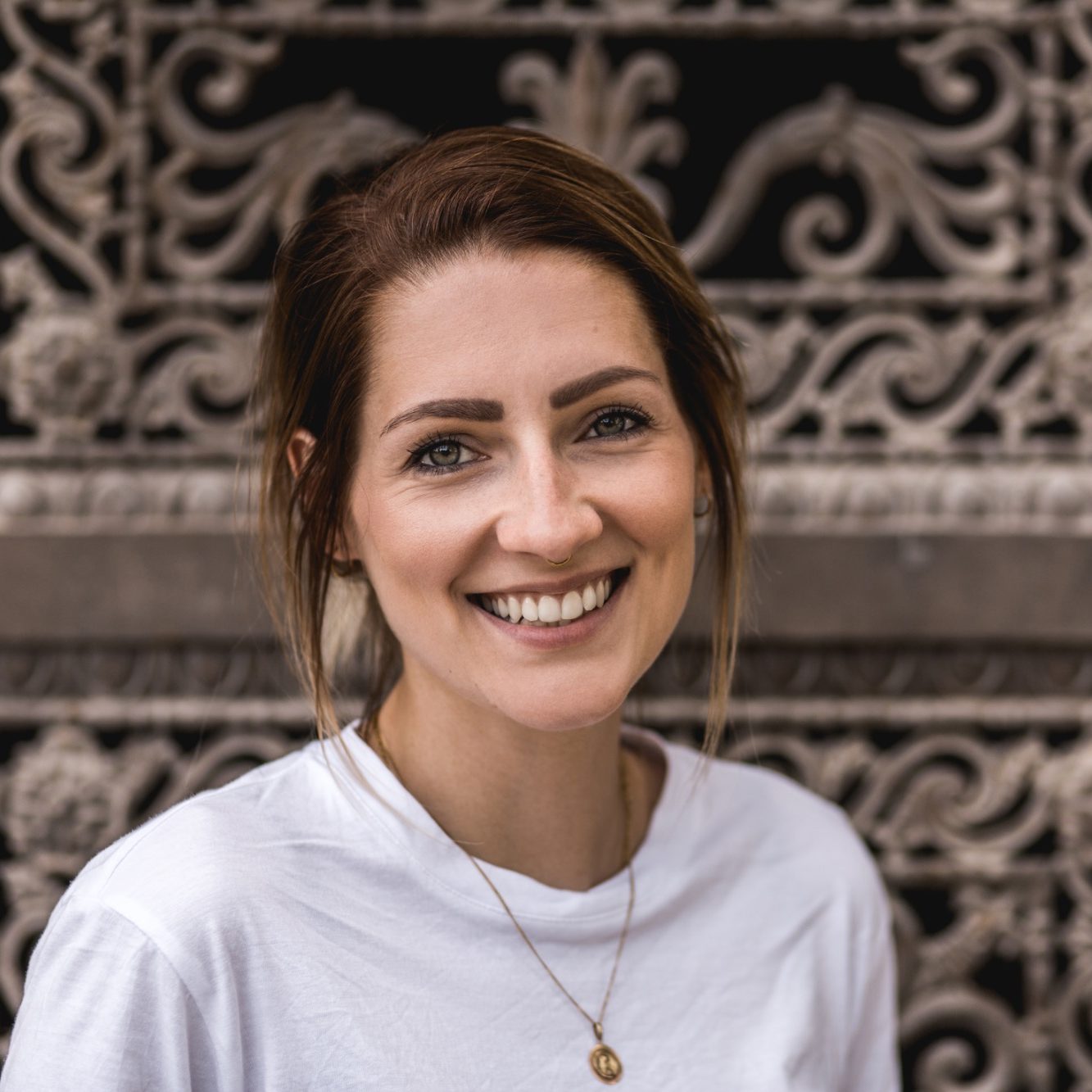 Professionelle Fotografin für Hochzeiten und Portraits Freundliches Portrait einer Hochzeits- und Portraitfotografin in natürlicher Umgebung.